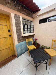 a yellow chair and a table in front of a building at Casita de pueblo, Cercana a los Volcanes in Tlalmanalco de Velázquez