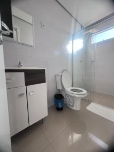 a bathroom with a toilet and a glass shower at IJUÍ APART HOTEl in Ijuí