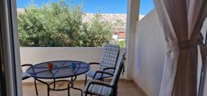 a patio with a table and chairs on a balcony at Apartments Burcul Pag in Pag