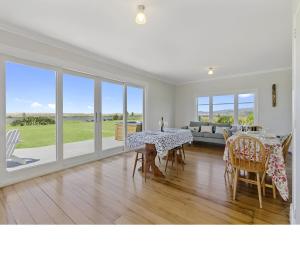a living room with a table and chairs and a couch at Waipu Dunes in Waipu