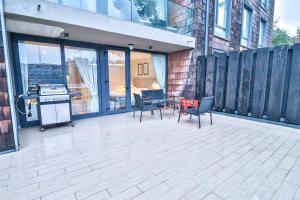 a patio with chairs and a table and a grill at HOM I Depto con Gran Terraza con Vista al Lago in Puerto Varas