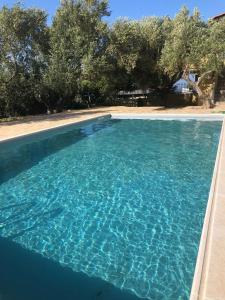 a large pool of blue water with trees in the background at Wunderschönes Ferienhaus In Agios Stefanos in Foútia