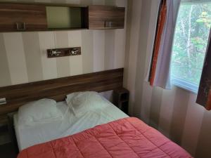 a bedroom with a bed and a television on the wall at Mobil-home pour 5 pers avec Terrasse - API-1-52-372 in Salles
