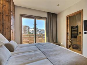 Un dormitorio con una cama grande y una ventana grande. en Chalet neuf à La Plagne avec parking et sauna - FR-1-455-267, en La Plagne Tarentaise