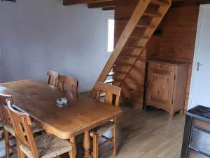 a dining room with a wooden table and wooden stairs at Chalet confortable 8 pers, 3 ch, poêle à bois - API-1-52-154 in Salles