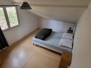 a small room with a bed in a attic at Chalet confortable 8 pers, 3 ch, poêle à bois - API-1-52-154 in Salles +11 photos
