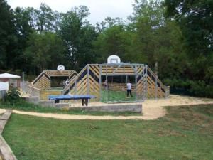 a man standing in a play structure in a park at Chalet confortable 8 pers, 3 ch, poêle à bois - API-1-52-154 in Salles