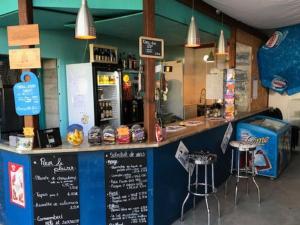 un restaurant avec un comptoir avec un bar et des tabourets dans l'établissement Mobil-home 30m² avec terrasse à Vendays-Montalivet - API-1-52-794, à Vendays-Montalivet