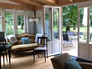 ein Wohnzimmer mit einem Sofa und Glastüren in der Unterkunft Gîte cosy près de Guérande avec Wi-Fi et terrasse - FR-1-306-1316 in Guérande