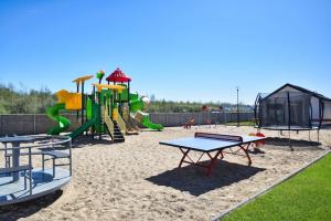 einen Spielplatz mit Rutsche und Spielgeräten in der Unterkunft Cozy holiday homes, close to the lake in Łazy
