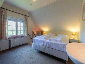 1 dormitorio con cama y lavamanos en Apartment in Vrouwenpolder near the Dunes, en Vrouwenpolder