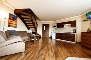 a living room with a couch and a kitchen at Holiday Home by Lake Jamno with Pool in Osieki
