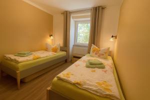 two beds in a small room with a window at Dünenlicht 32 in Prerow