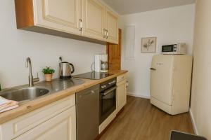a kitchen with a sink and a refrigerator at Dünenlicht 32 in Prerow
