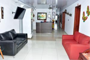 a living room with red and black furniture and a counter at CasaHotel Linda V in Montería