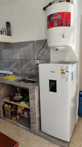 a white refrigerator with a water tank on top of it at Alquiler Temporario Oliva in Oliva +13 photos