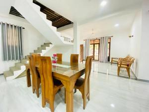 a dining room with a wooden table and chairs at Akee villa in Matara