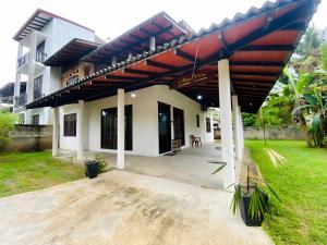 a house with a large red awning on it at Akee villa in Matara