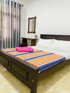 a bedroom with a bed with an colorful blanket on it at Akee villa in Matara
