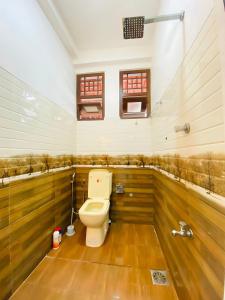 a bathroom with a toilet with wood paneling at Akee villa in Matara +25 photos