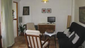 a living room with a couch and a tv at Al Sil Ram in Alfacar