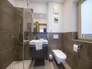 a bathroom with a toilet and a sink and a shower at Stylish Chalet by Ski Slopes in Neukirchen am Großvenediger +45 photos