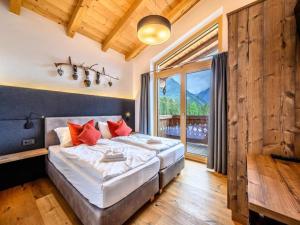 a bedroom with a bed and a large window at Family Chalet Escape in the Alps in Neukirchen am Großvenediger