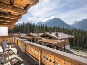 a balcony with chairs and a view of mountains at Family Chalet Escape in the Alps in Neukirchen am Großvenediger