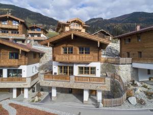 a group of wooden buildings with mountains in the background at Chalet Stay near Krimml Waterfalls in Neukirchen am Großvenediger