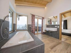 ノイキルヒェン・アム・グロースヴェンエーディガーにあるChalet near Wildkogel Arenaの大きなバスルーム(バスタブ付)、大きな窓が備わります。 +46枚の写真