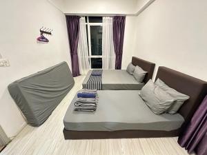 a living room with two beds and a couch at SA Sutera Avenue Homestay - Kota Kinabalu Area KK City Opposite Imago in Kota Kinabalu +34 photos