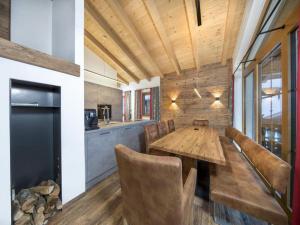 a dining room with a wooden table and chairs at Chalet with shared swimming pool in Neukirchen am Großvenediger