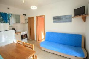 ein Wohnzimmer mit einem blauen Sofa und einem Tisch in der Unterkunft Holiday Home in Brac near Golden Horn Beach in Sumartin + 20 Fotos