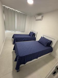 two beds in a small room with blue sheets at Apartamento, Apart Hotel, 02 Quartos - Arraial do Cabo in Arraial do Cabo +12 photos