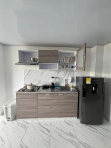 a kitchen with a black refrigerator and a counter at Axé Shelter in Sogamoso +14 photos