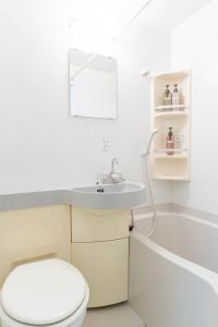 Un baño con inodoro, lavabo y bañera. en Uburu Apartment, en Fukuoka