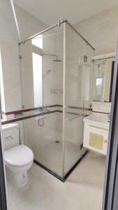 une salle de bain avec une douche en verre et des toilettes dans l'établissement HomeStay Khánh Linh B1 Hồ Quý Ly, à Vung Tau