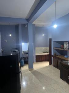 a kitchen with blue walls and a kitchen with a refrigerator at Wiz Holiday Home in Badulla