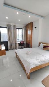 une chambre avec un grand lit et un bureau dans l'établissement HomeStay Khánh Linh B1 Hồ Quý Ly, à Vung Tau