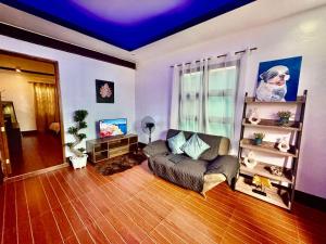 a living room with a couch and a tv at Polos Place Homestay in Sorsogon