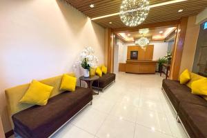 a lobby with couches and yellow pillows at LuxeLite Suites Pasay in Pasay