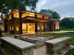 a large house with a fire pit in the yard at Loto San Lorenzo Loft l Piscina & Naturaleza in San Lorenzo
