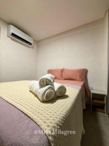 ein Schlafzimmer mit einem Bett mit Handtüchern darauf in der Unterkunft MHV Milagres - Casa Aurora, Refugio a poucos metros da Paradisíaca Praia do Marceneiro in Passo de Camarajibe