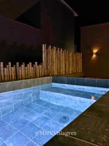 ein Swimmingpool mit blauen Fliesen und einem Holzzaun in der Unterkunft MHV Milagres - Casa Aurora, Refugio a poucos metros da Paradisíaca Praia do Marceneiro in Passo de Camarajibe