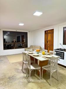 eine Küche und ein Esszimmer mit Tisch und Stühlen in der Unterkunft MHV Milagres - Casa Aurora, Refugio a poucos metros da Paradisíaca Praia do Marceneiro in Passo de Camarajibe + 47 Fotos
