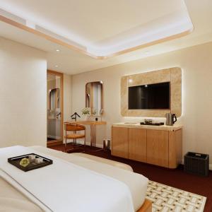 a hotel room with a bed and a television at The Haron Hanoi Boutique Hotel in Hanoi