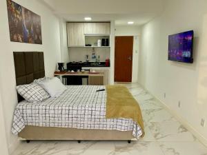 a bedroom with a bed and a kitchen at Território Afeto Odara in Rio de Janeiro