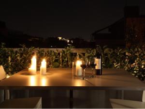 Athens View Loft - 04 في أثينا: طاولة مع الشموع وكؤوس النبيذ وزجاجات النبيذ