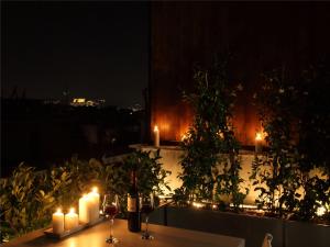 アテネにあるAthens View Loft - 05の夜間のバルコニーにキャンドルと照明付きのテーブル
