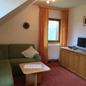 - un salon avec un canapé et une télévision dans l'établissement Gasthof Dachsteinblick, à Stainach